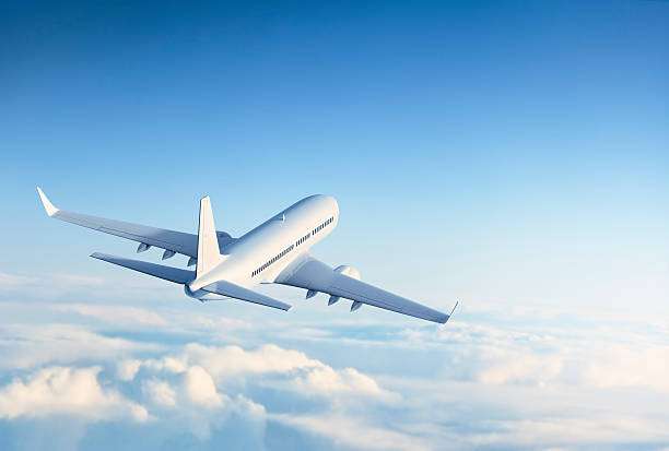 commercial jet flying above clouds.