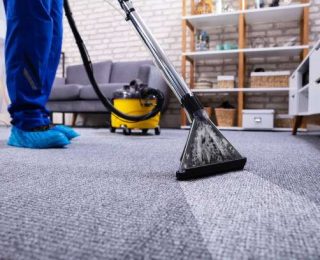 human cleaning carpet in the living room using vacuum cleaner at home